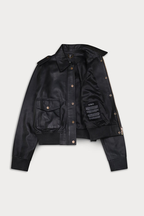 A black leather jacket  button-up front, and two front flap pockets with brass-tone snaps, displayed open. Amelia -Sly&Co