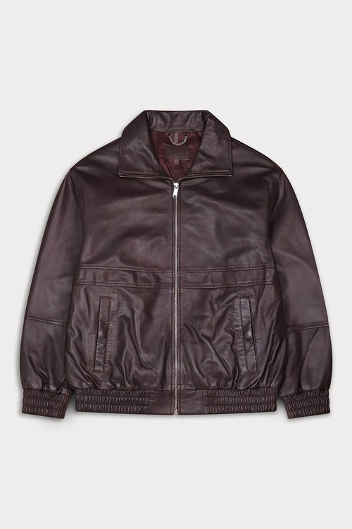 A dark brown leather jacket with a front zipper, ribbed elastic cuffs and hem, and zippered front pockets.