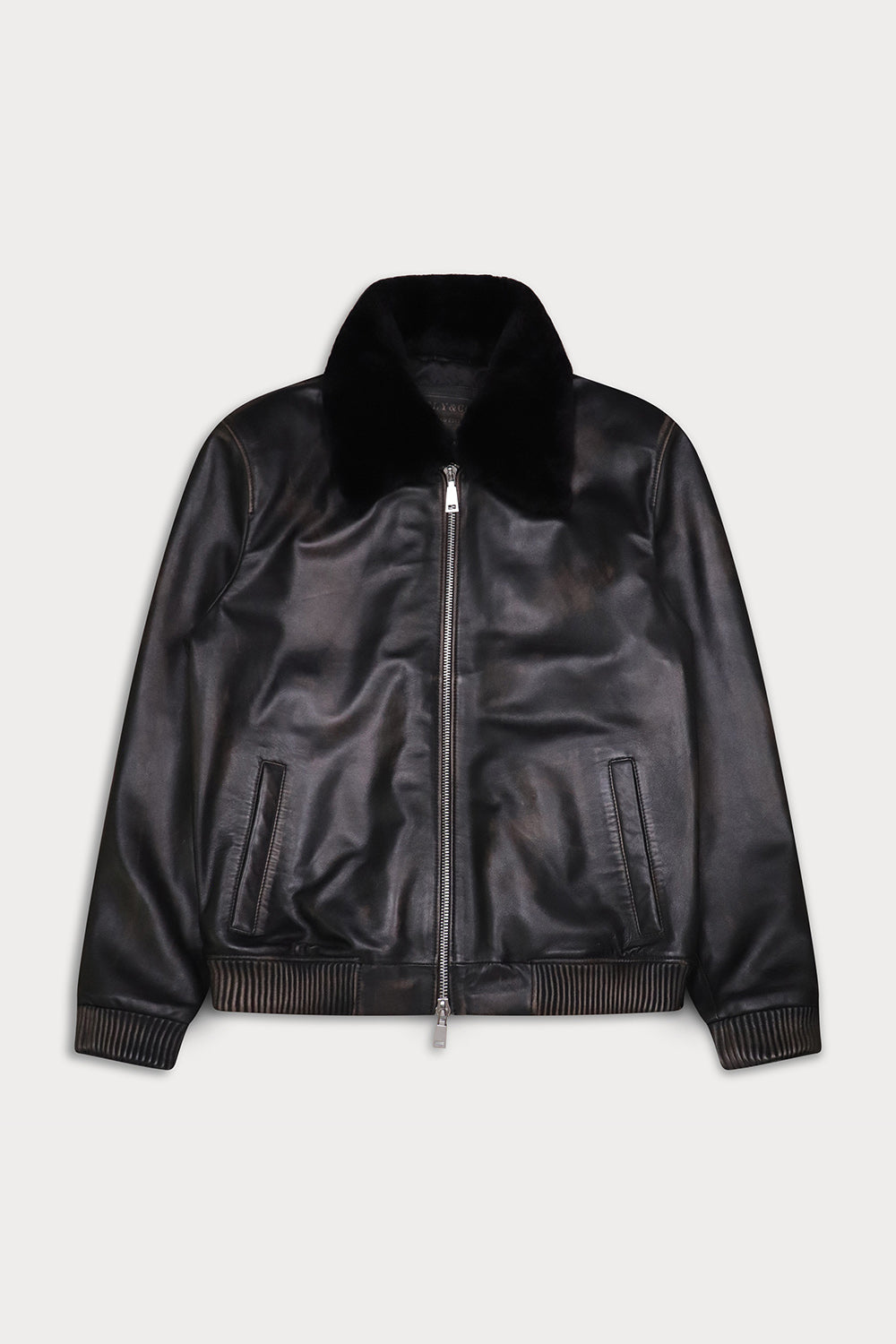A black leather bomber jacket with a plush black faux-fur collar, ribbed knit trim at the cuffs and hem, and a silver-tone front zipper