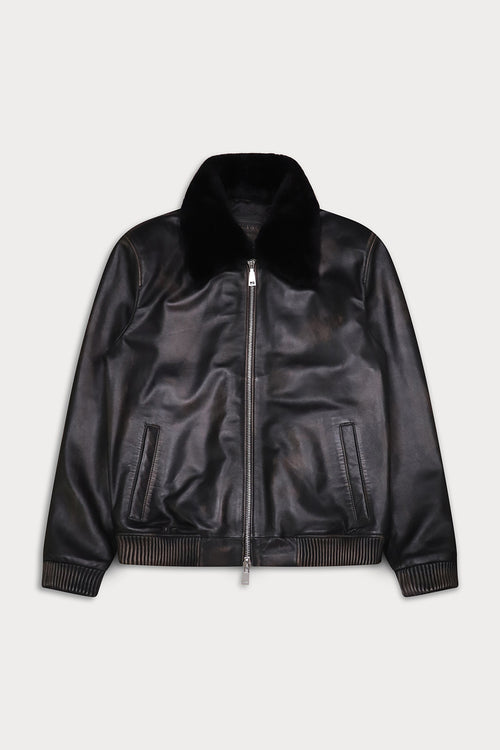 A black leather bomber jacket with a plush black faux-fur collar, ribbed knit trim at the cuffs and hem, and a silver-tone front zipper