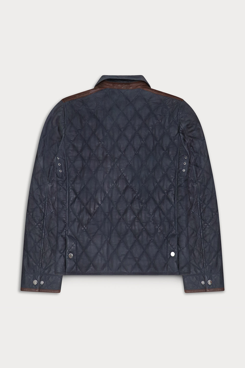 A dark navy blue quilted jacket with brown leather shoulder panels and snap-button details