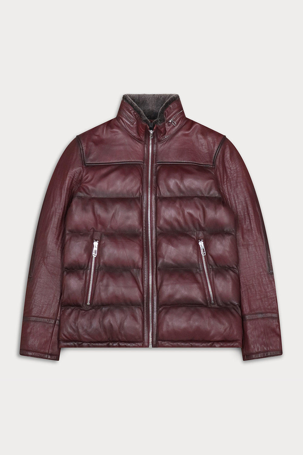 A dark burgundy leather jacket with a quilted puffer body, zippered front and pockets, and a high collar, shown flat against a light gray background.