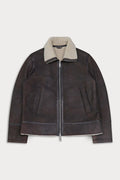 A dark brown suede leather aviator jacket with a beige shearling-style collar. Mukabi-Sly&co