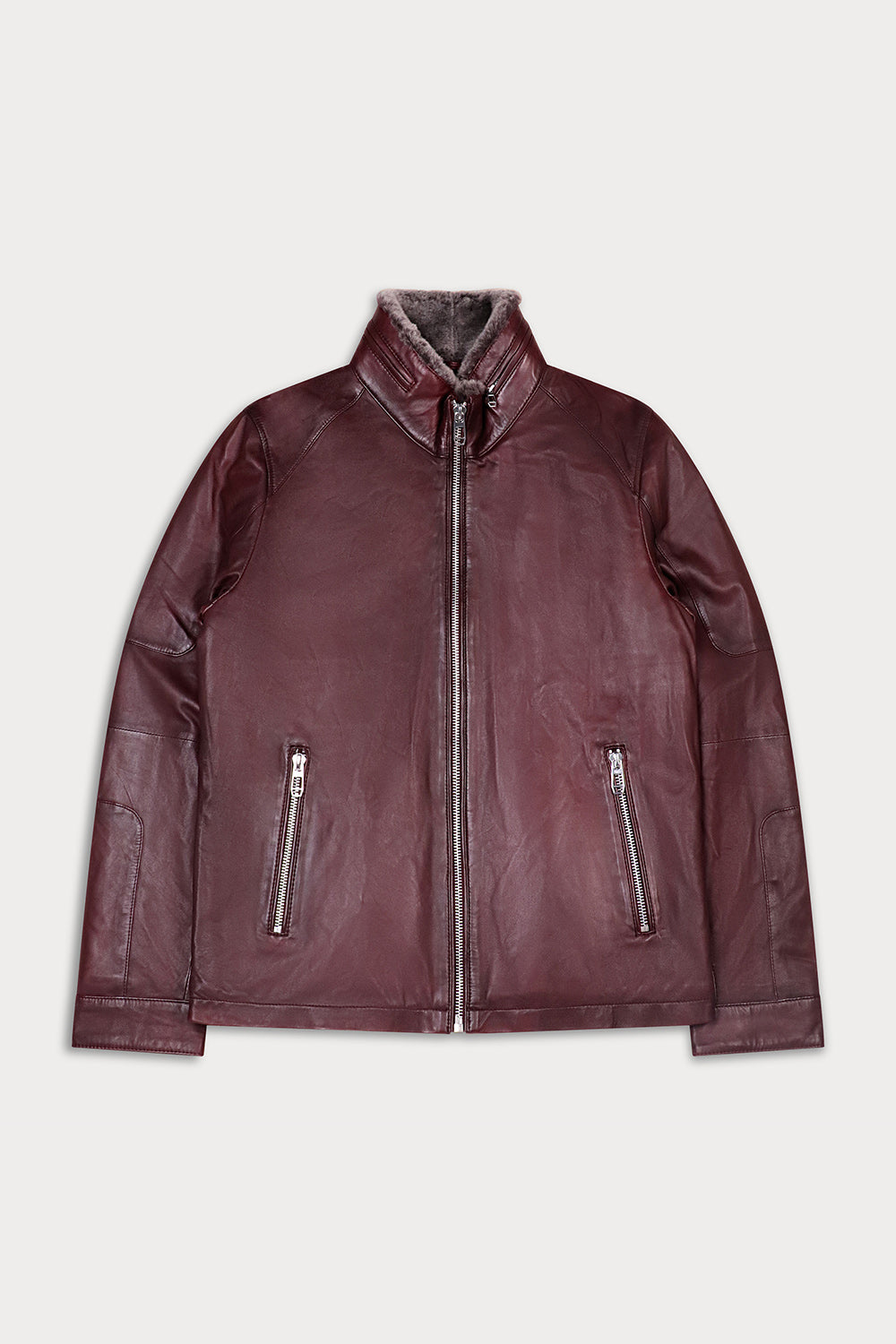 A dark burgundy leather jacket with a high collar, front zipper, and two vertical zippered pockets.