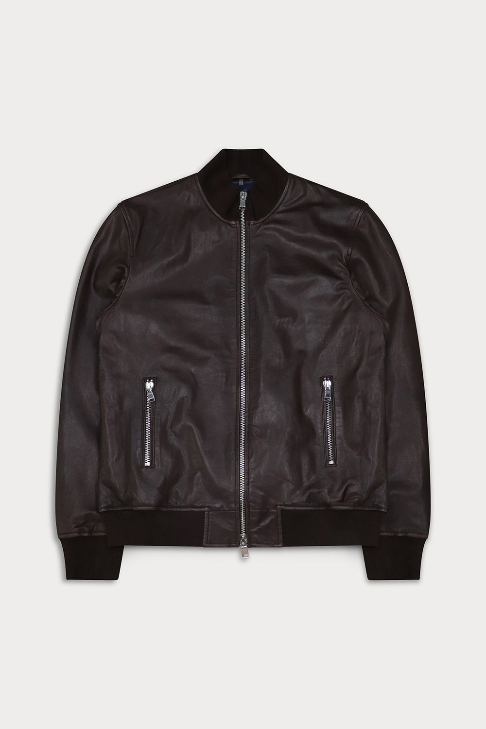 A dark brown leather bomber jacket with a silver front zipper and zippered pockets, displayed flat against a light gray background.