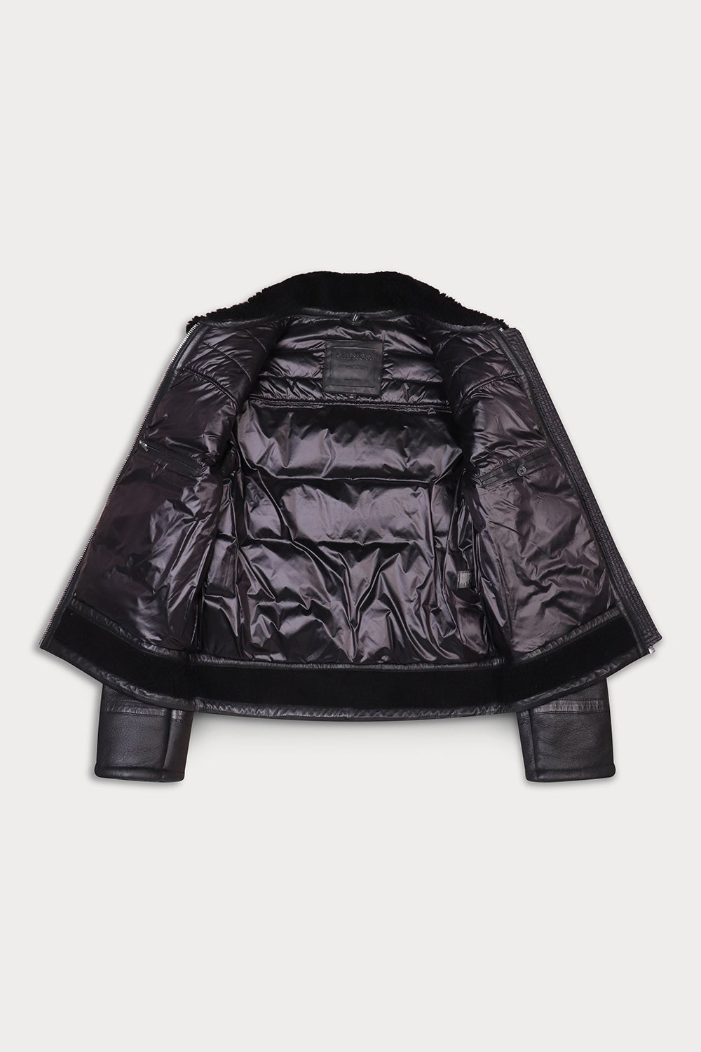 A cropped black leather jacket with a quilted puffer front, zippered pockets, and a black fur collar show open