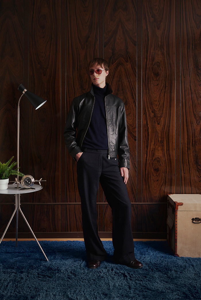 A male model wearing a black leather jacket from Sly&Co